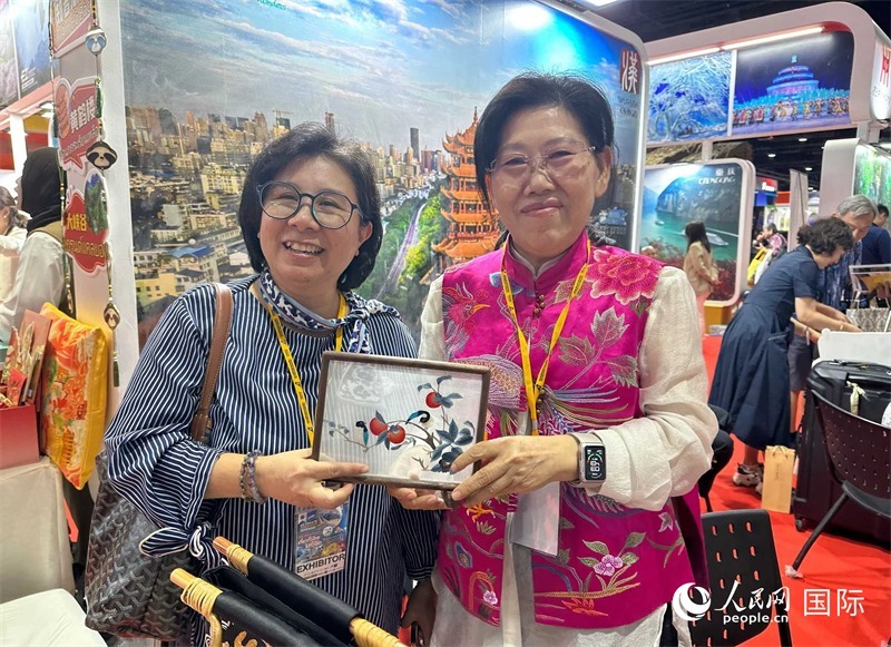 中國“大冶刺繡”傳承人劉小紅（右）參加泰國國際旅游展，向觀眾介紹中國非遺刺繡針法。人民網(wǎng)記者 簡(jiǎn)承淵攝