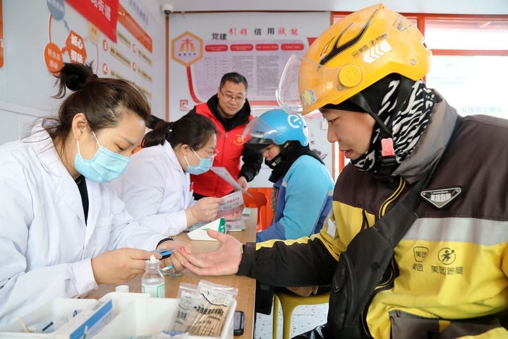 2025年3月5日，志愿者在山東省棗莊市市中區(qū)一工會驛站為外賣員免費(fèi)測量血糖。新華社發(fā)（王海楠攝）