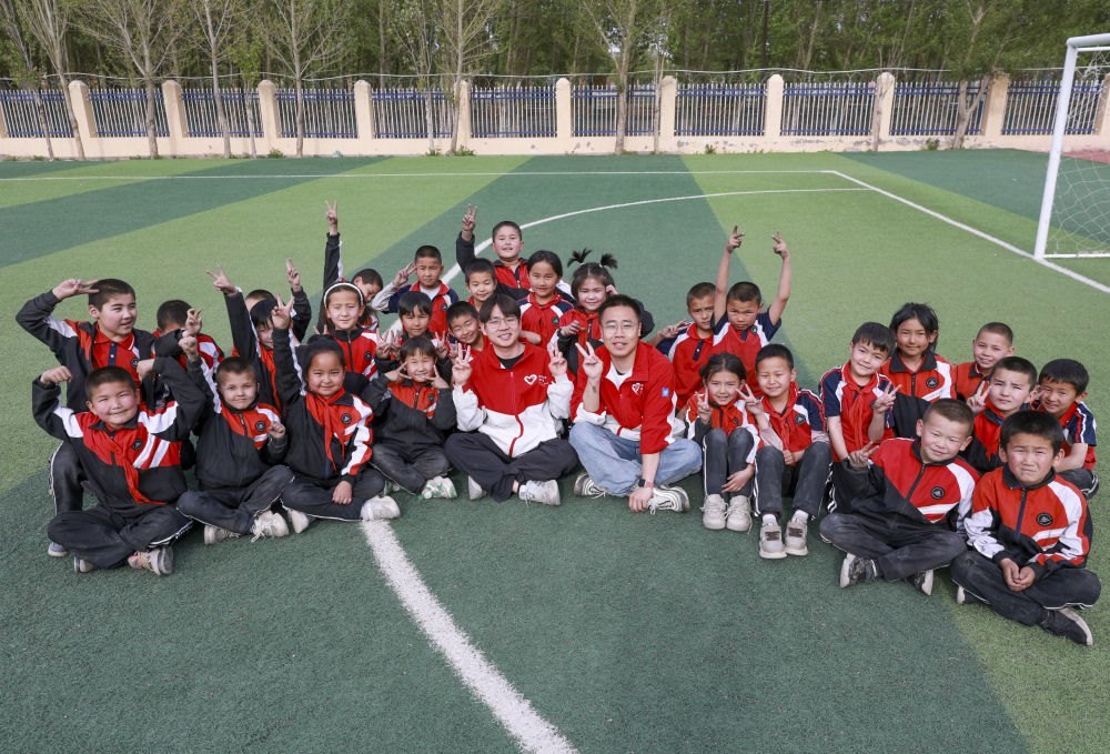 4月23日，在新疆克州阿圖什市哈拉峻鄉(xiāng)謝依特小學，支教教師王俊文（中左）、李軻凡（中右）和學生在一起。