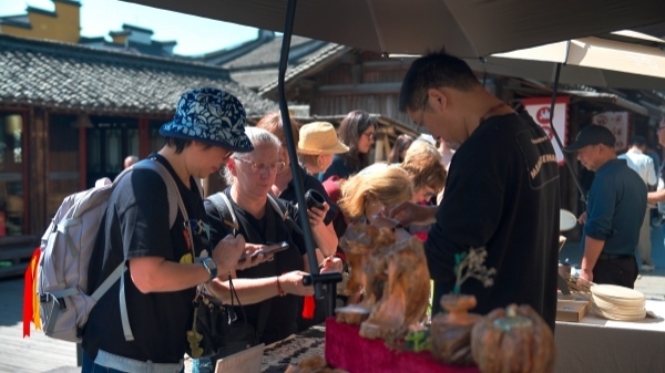 “五一”期間，游客正在烏鎮(zhèn)“水鄉(xiāng)碼頭”挑選購(gòu)買文創(chuàng)產(chǎn)品。受訪者供圖