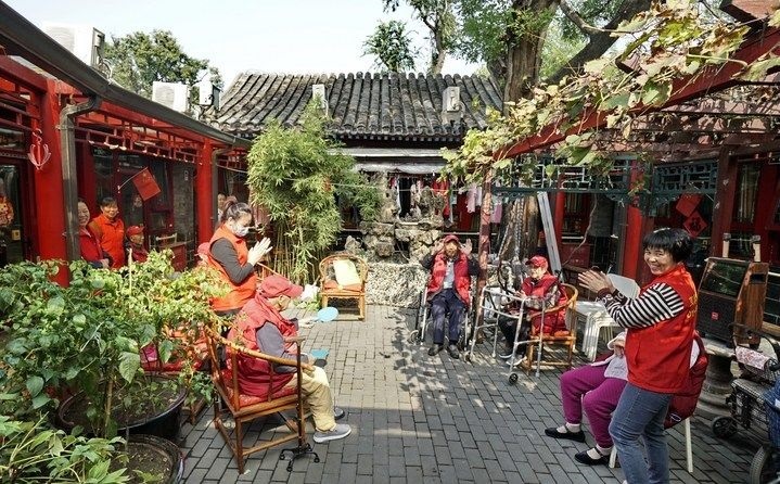 2024年10月12日，鐘樓灣胡同的老年人在社區(qū)內(nèi)的四合院養(yǎng)老驛站休閑。2017年起，北京市先后開展了兩輪背街小巷環(huán)境整治提升行動，完整保留了中軸線生活建筑群的歷史信息，并根據(jù)居民的生活和居住方式進(jìn)行適配化的更新和改造，極大地改善了生活環(huán)境。2023年鐘樓灣胡同被評為“北京最美街巷”。