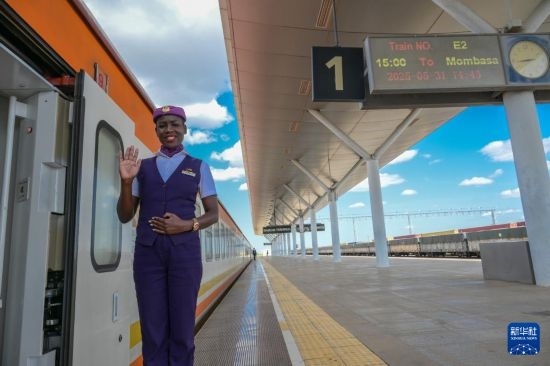 5月31日，在蒙內(nèi)鐵路內(nèi)羅畢站，一名乘務(wù)員在即將開往蒙巴薩的E2次列車旁等候乘客。新華社記者 楊光 攝