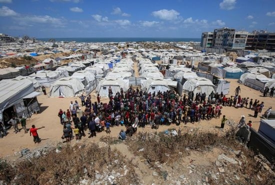 5月28日，人們在加沙城西部的沙提難民營等待領(lǐng)取救助食物。新華社發(fā)（里澤克·阿卜杜勒賈瓦德攝）