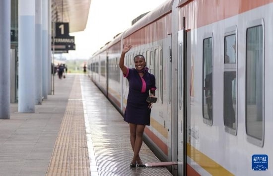 5月31日，在蒙內(nèi)鐵路內(nèi)羅畢站，一名乘務(wù)員在即將開往蒙巴薩的E2次列車旁等候乘客。新華社記者 李亞輝 攝